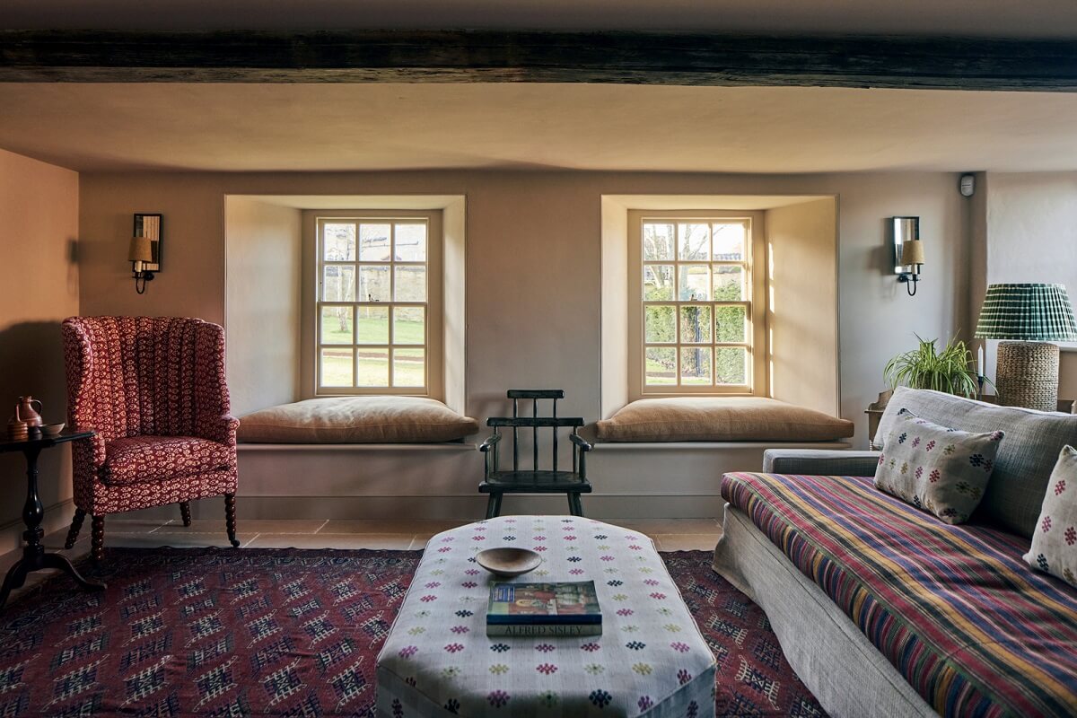 A Historic English Country House with Restored Interiors 7 cozy sitting room with low ceiling window seats and exposed beam