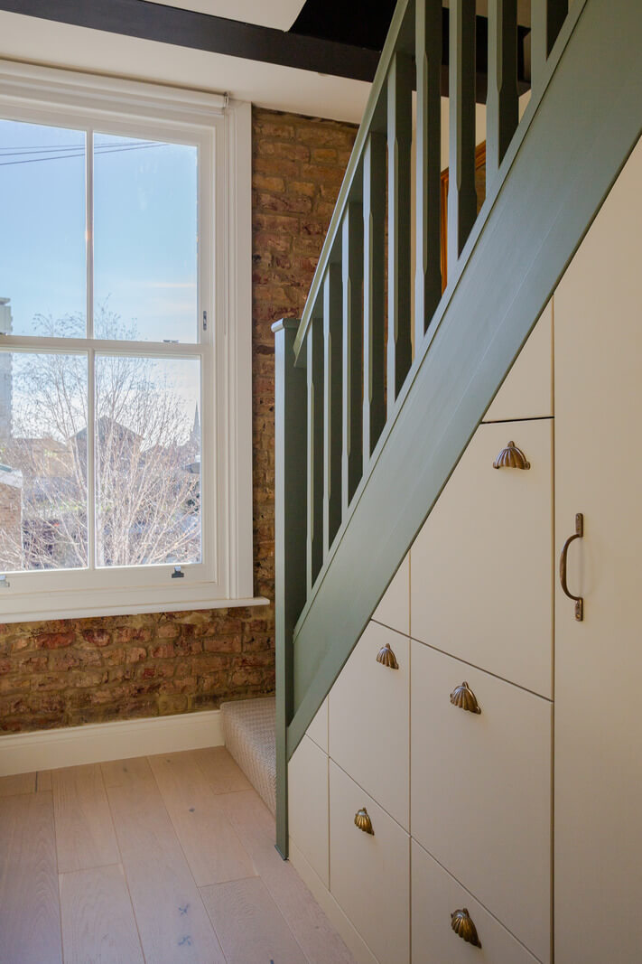 An Exposed Brick Wall in a London Duplex Apartment 3 custom under stairs storage
