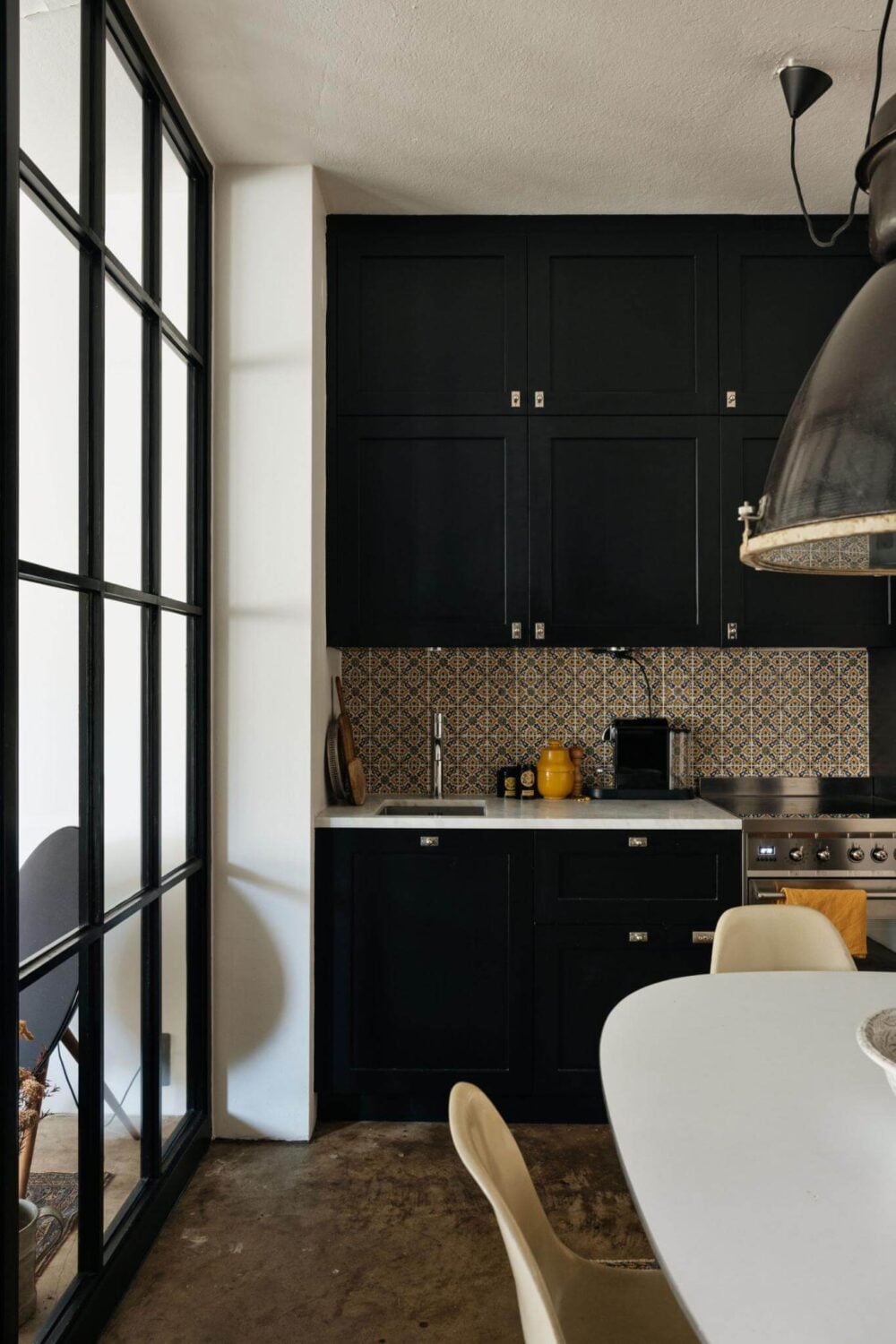 An Industrial Apartment with Black Walls 3 dark blue kitchen and induustrial glass wall nordroom