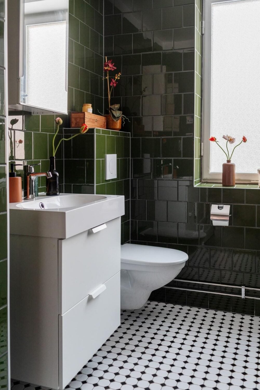A Small Swedish Apartment with Warm Color Accents 22 glossy green tiles and black white floor tiles in small bathroom