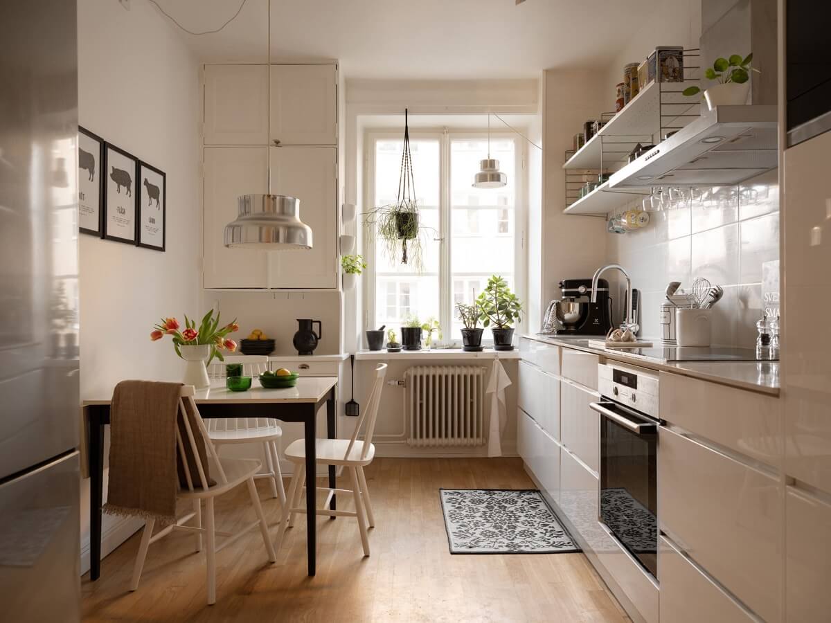 A Swedish Apartment with Light-Filled Rooms 6 kitchen with modern white cabinets and small dining table