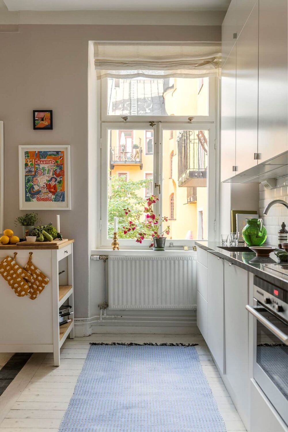 A Small Split-Level Apartment in Stockholm 8 kitchen with white cabinets and light gray walls