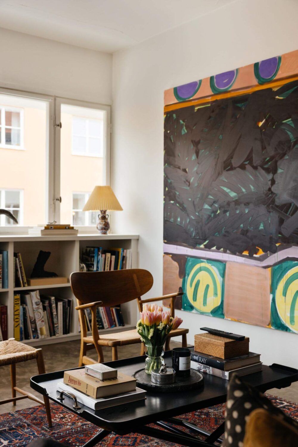 An Industrial Apartment with Black Walls 8 living room with large wall art and bookshelves