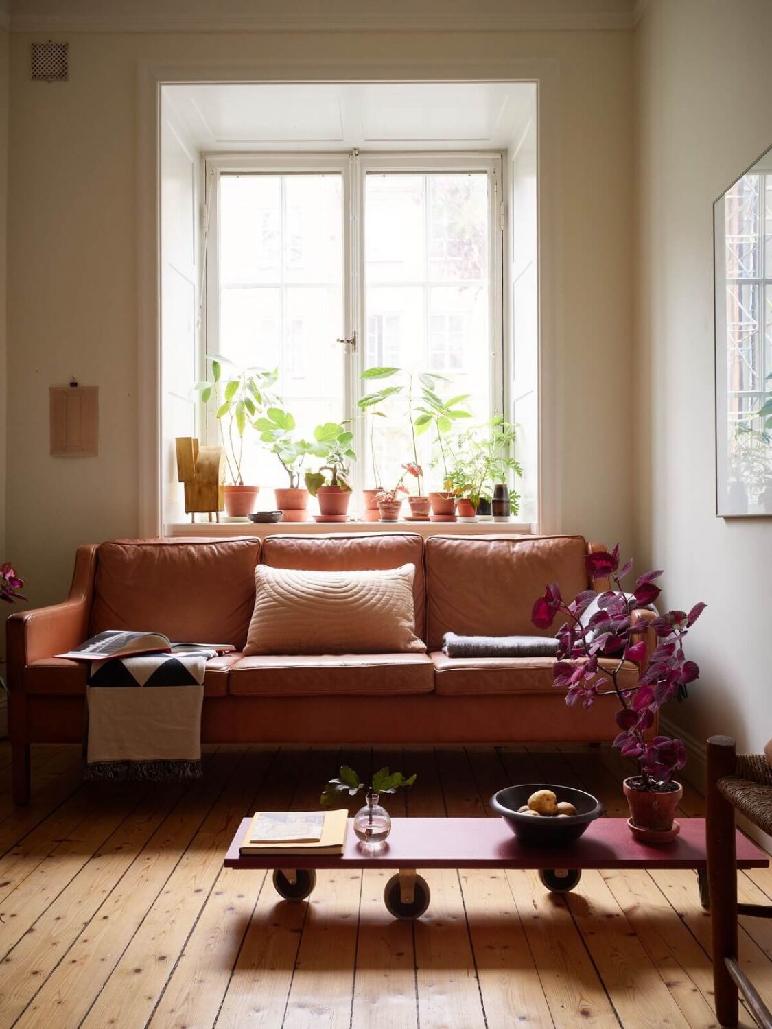 A Cozy Swedish Apartment Filled with Charm 3 living room with leather sofa and red coffee table