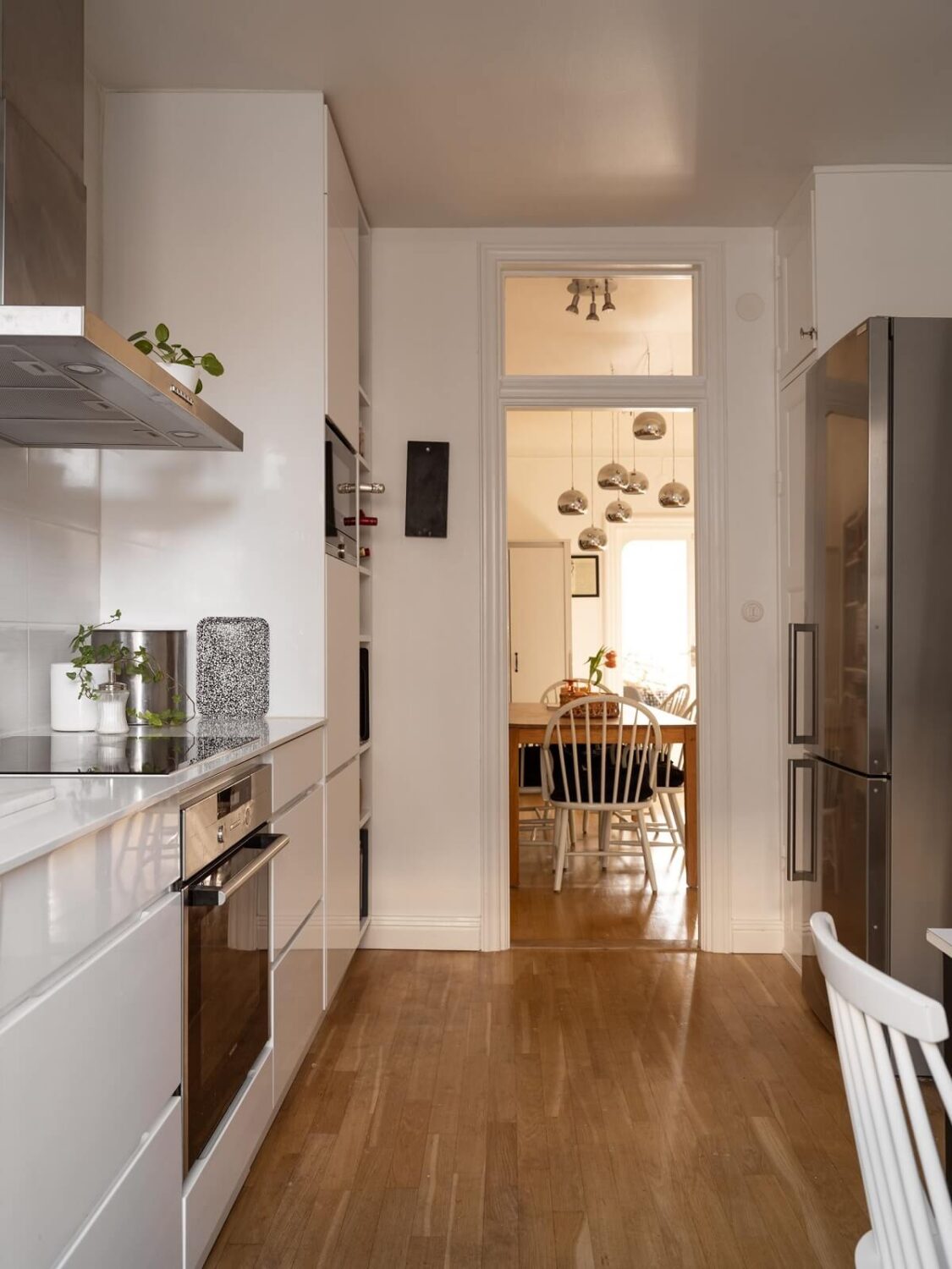 A Swedish Apartment with Light-Filled Rooms 9 modern wite kitchen with wooden floor