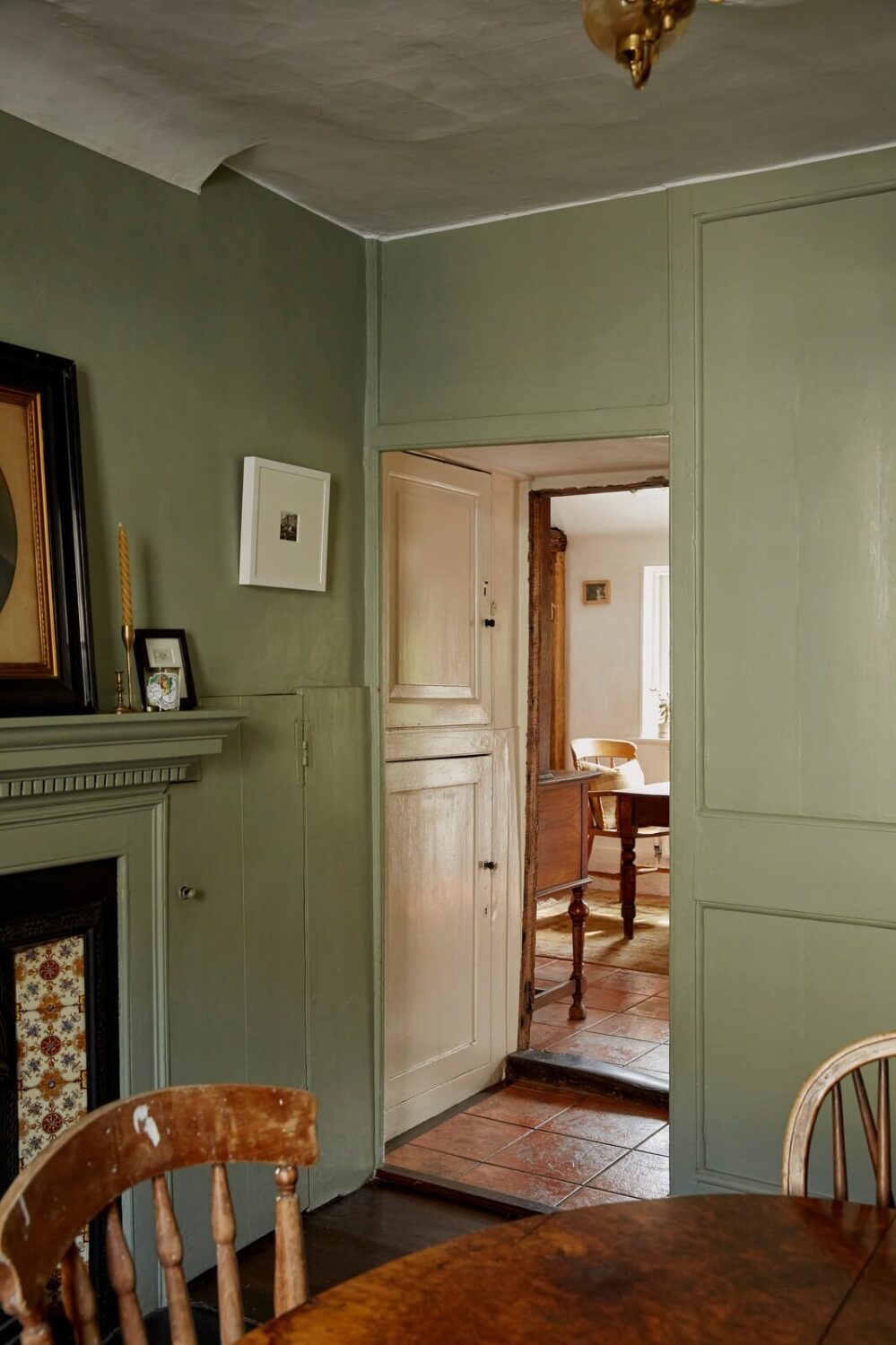 A Cozy Home with Exposed Beams in a Former Post Office 5 muted-green-walls-dining-room-with-fireplace-nordroom