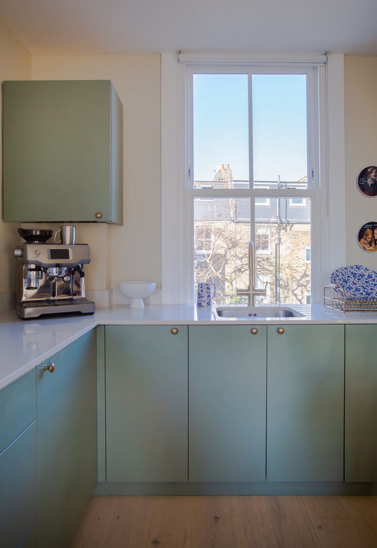 An Exposed Brick Wall in a London Duplex Apartment 12 sage green modern kitchen cabinets