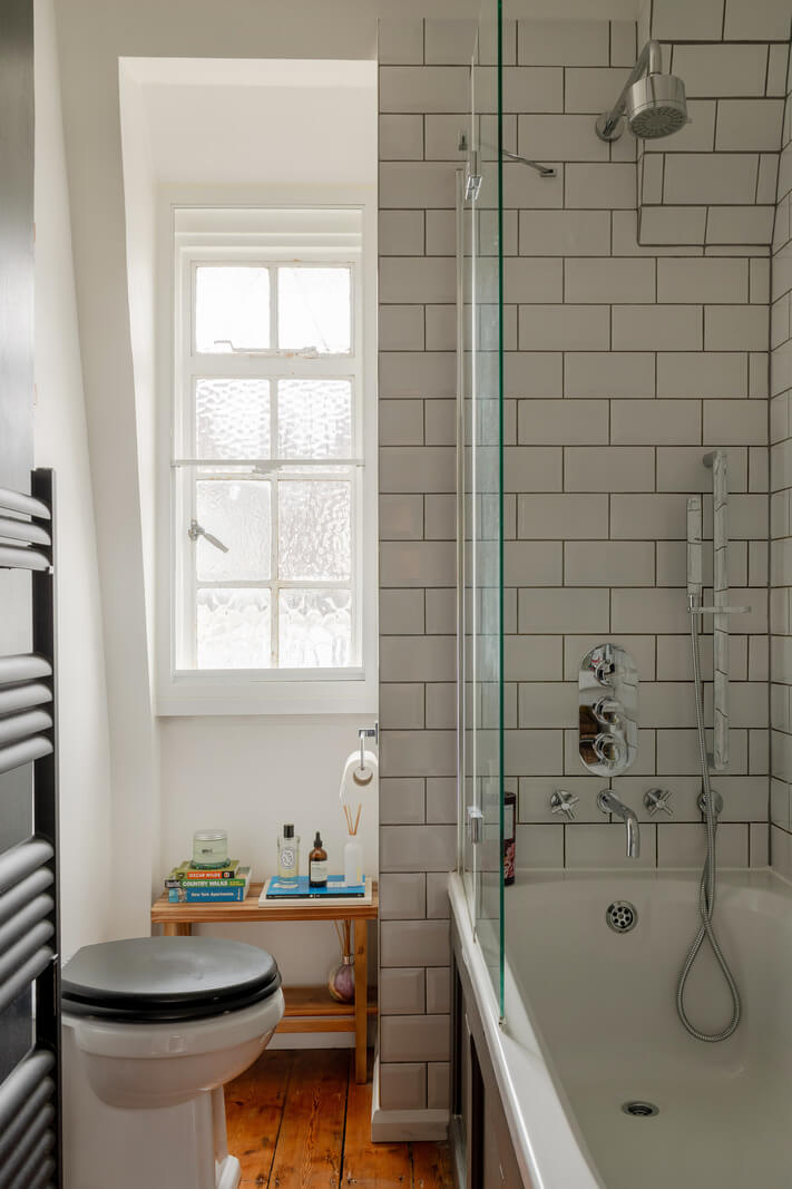 A Charming Top-Floor Apartment in an Art Deco Building 14 small bathroom with bath and subway tiles wooden floor nordroom