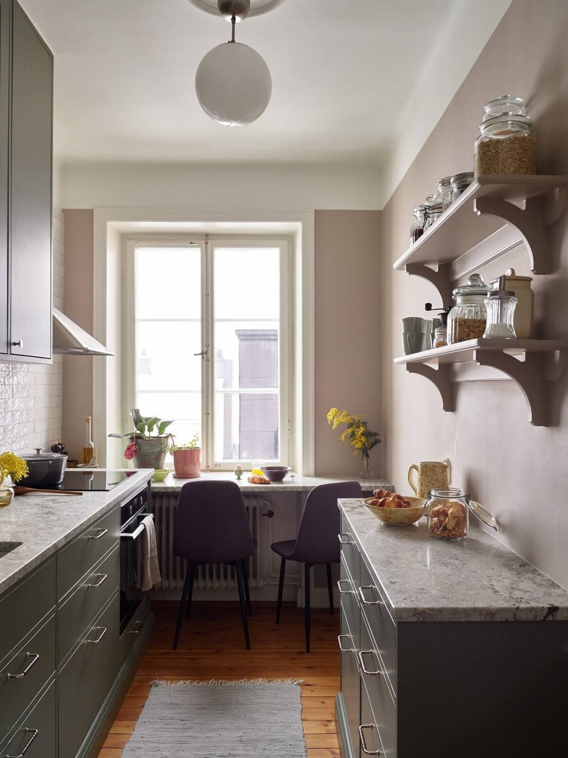 Green Tones in a Renovated Stockholm Duplex Apartment 6 small gray kitchen with bar seating in front of a window