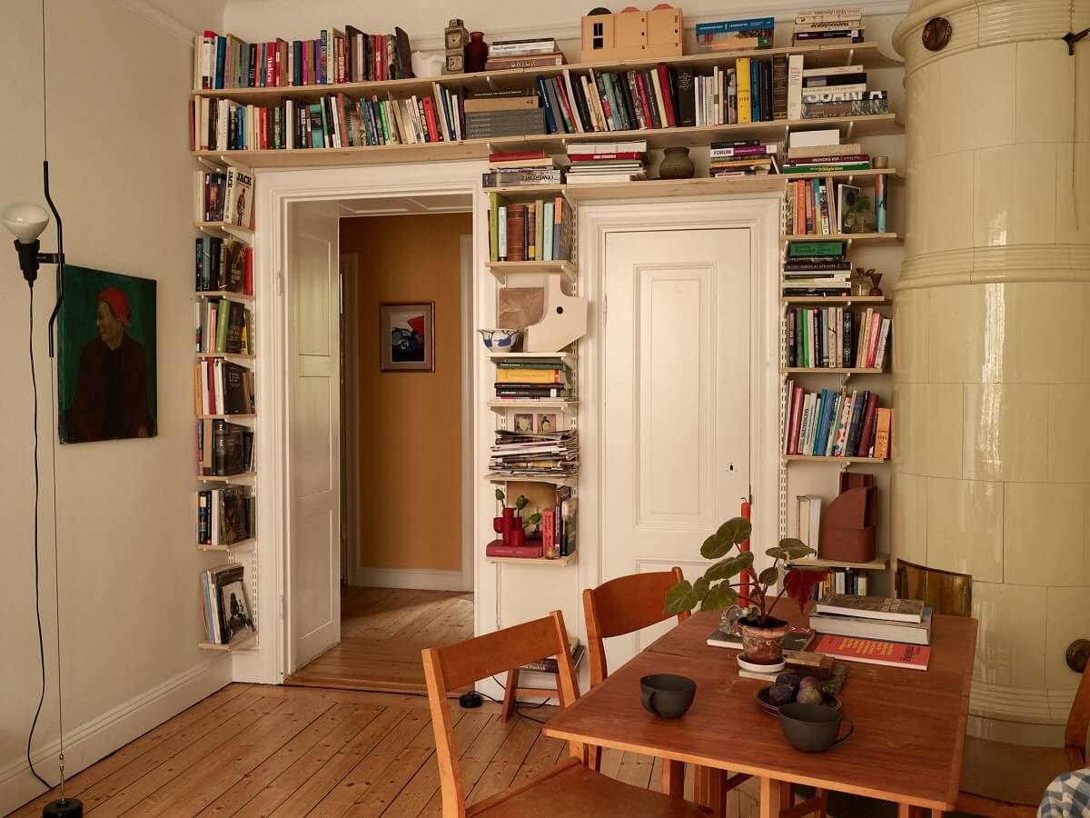 A Cozy Swedish Apartment Filled with Charm 8 small living room with bookshelves around doorframe