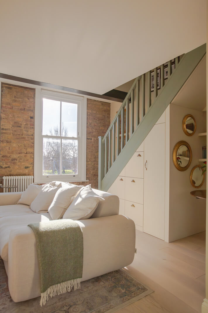 An Exposed Brick Wall in a London Duplex Apartment 13 storage cabinets under stairs