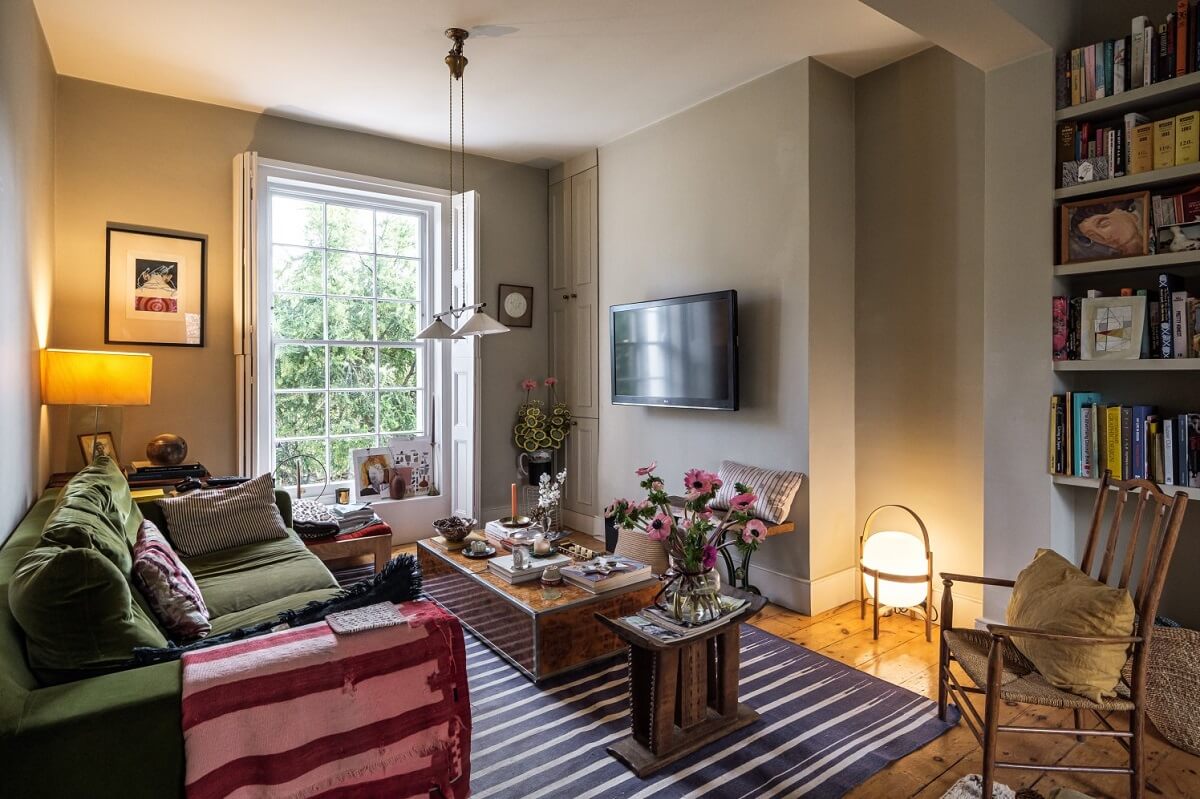 A Cozy and Charming Georgian Townhouse in London 2 tv room with green sofa and striped rug