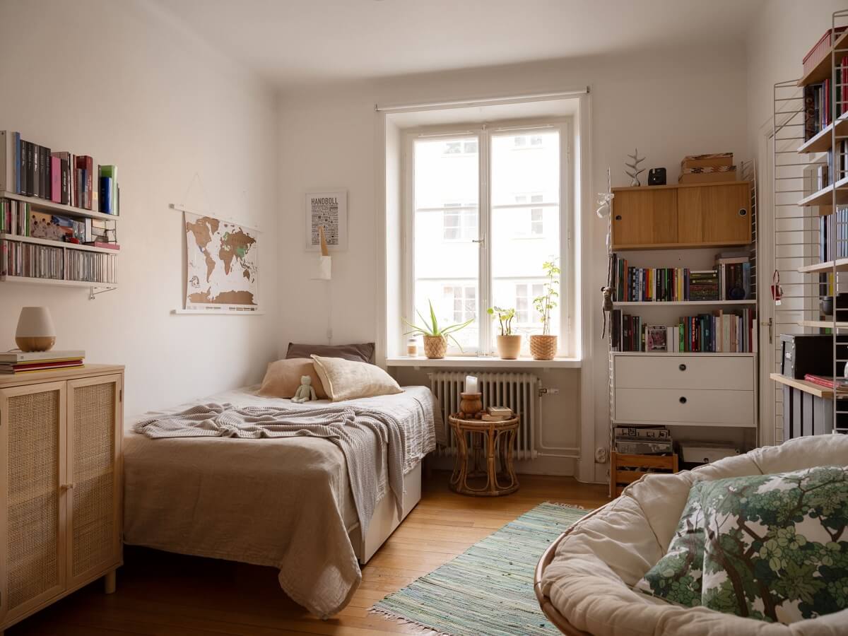 A Swedish Apartment with Light-Filled Rooms 13 white bedroom with bookshelves and round chair