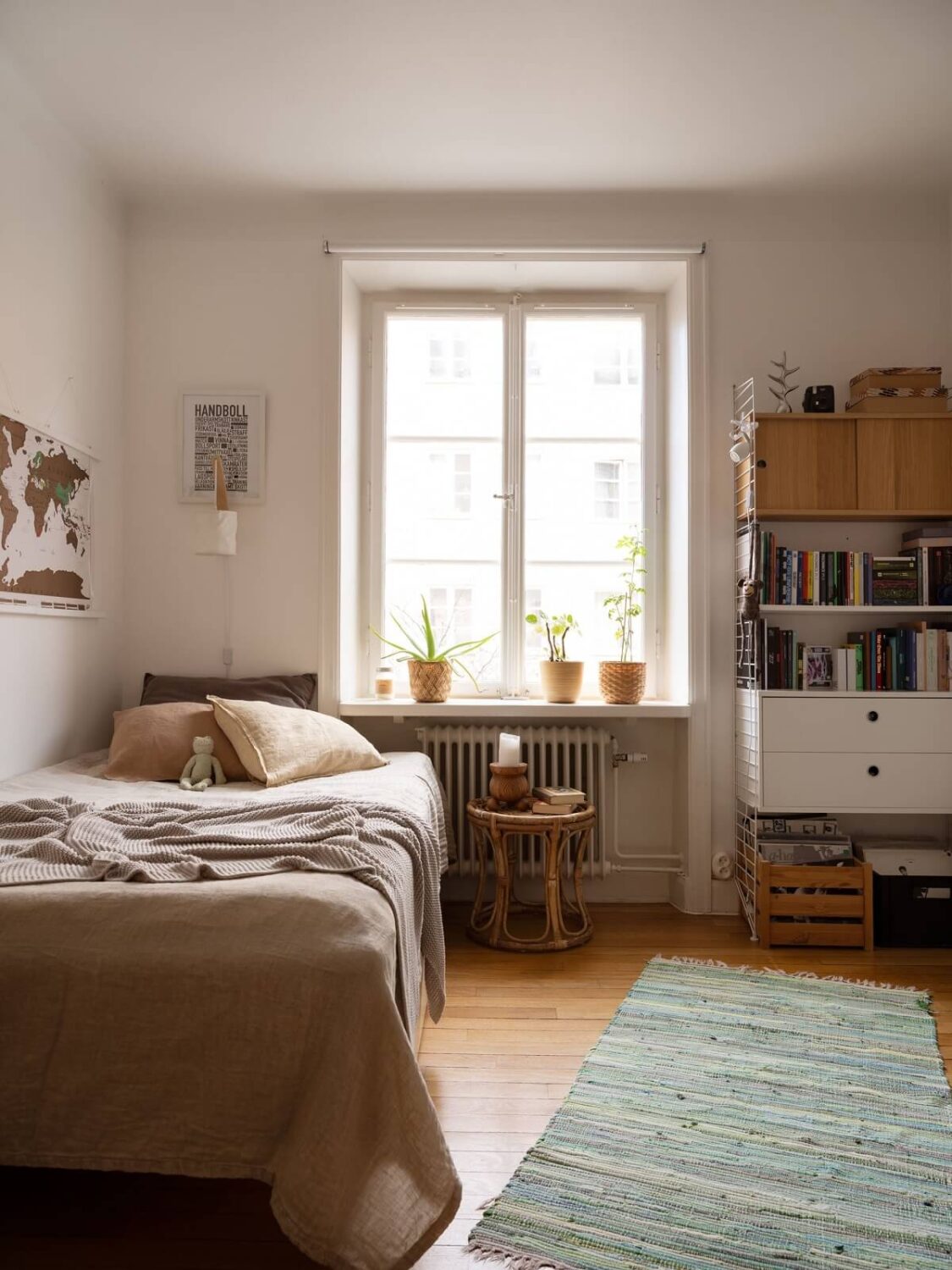 A Swedish Apartment with Light-Filled Rooms 14 white bedroom with rug and bookshelves