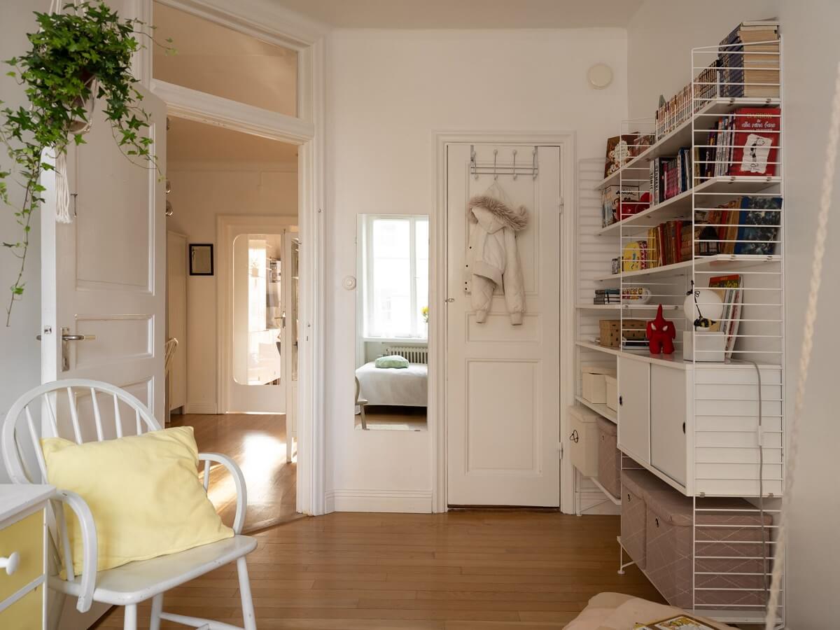 A Swedish Apartment with Light-Filled Rooms 12 white bedroom with string bookshelves