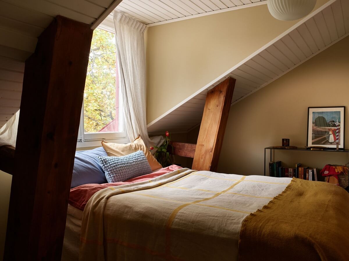 A Small Attic Apartment with a Golden Yellow Bedroom 13 attic bedroom with wooden beams