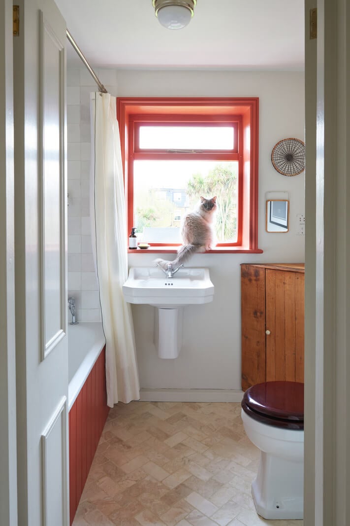 A Small Cottage-Style Apartment in London 13 bathroom with orange red details