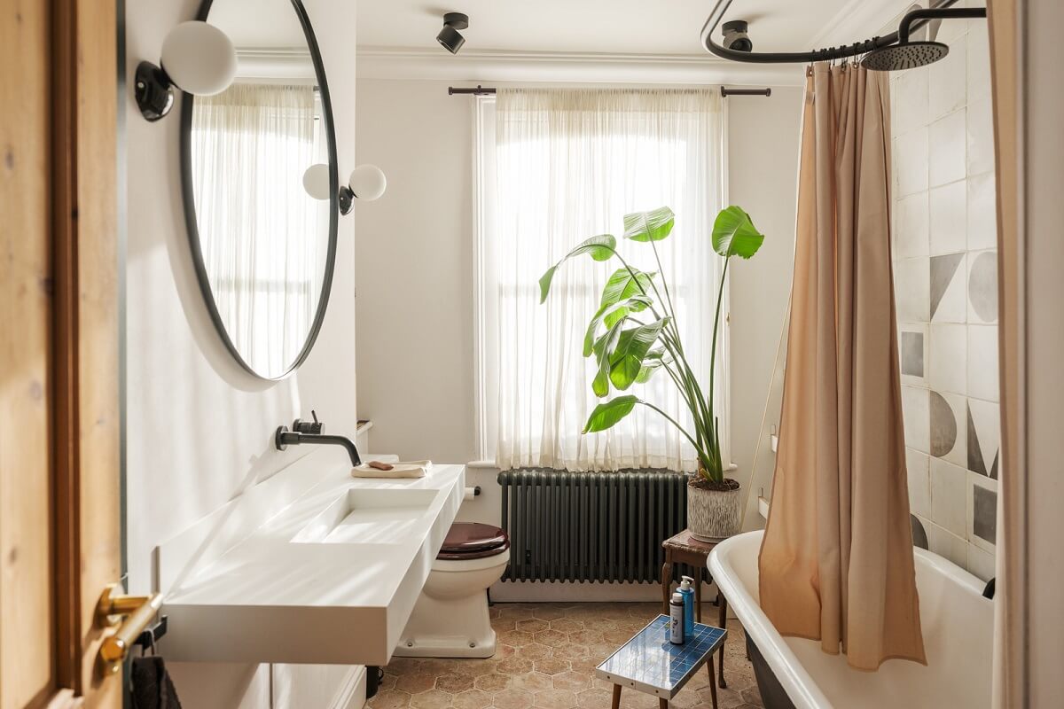 A London Home with Green Color Accents 16 bathroom with stone floor and clawfoot bath
