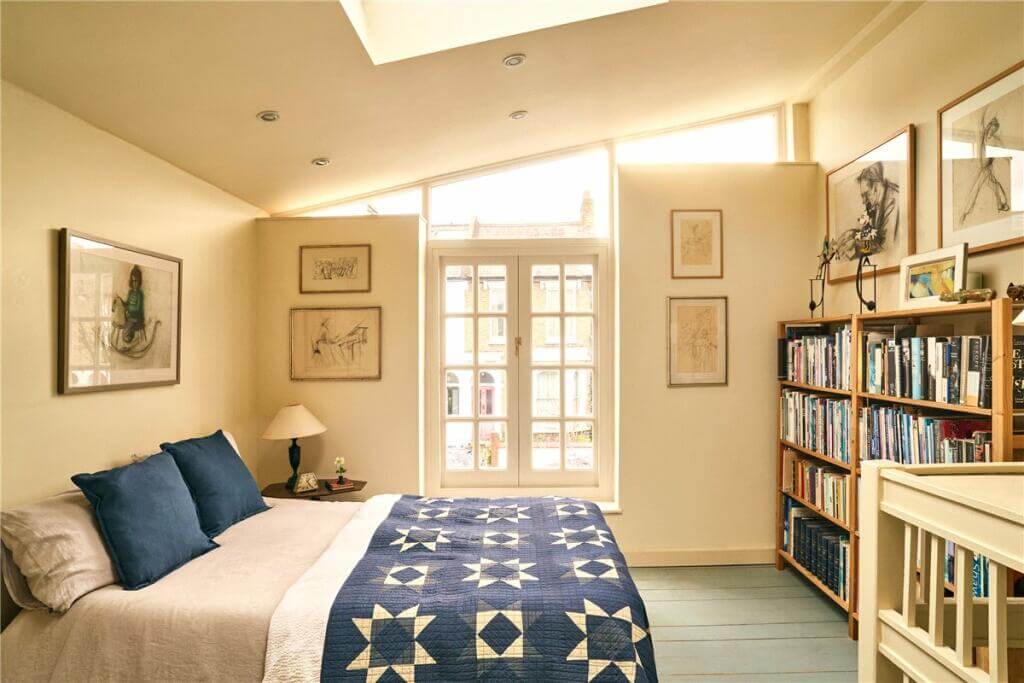 A Warm Muted Color Palette in a Victorian House 35 bedroom with beige walls and slanted ceiling with skylight