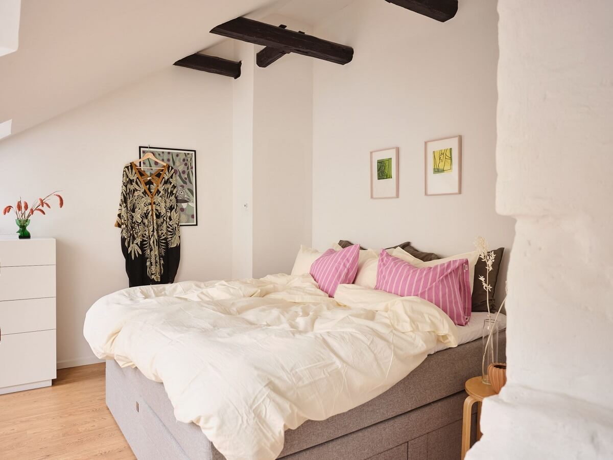 A Light Filled Duplex Apartment in Sweden 20 bedroom with slanted ceiling and wooden beams
