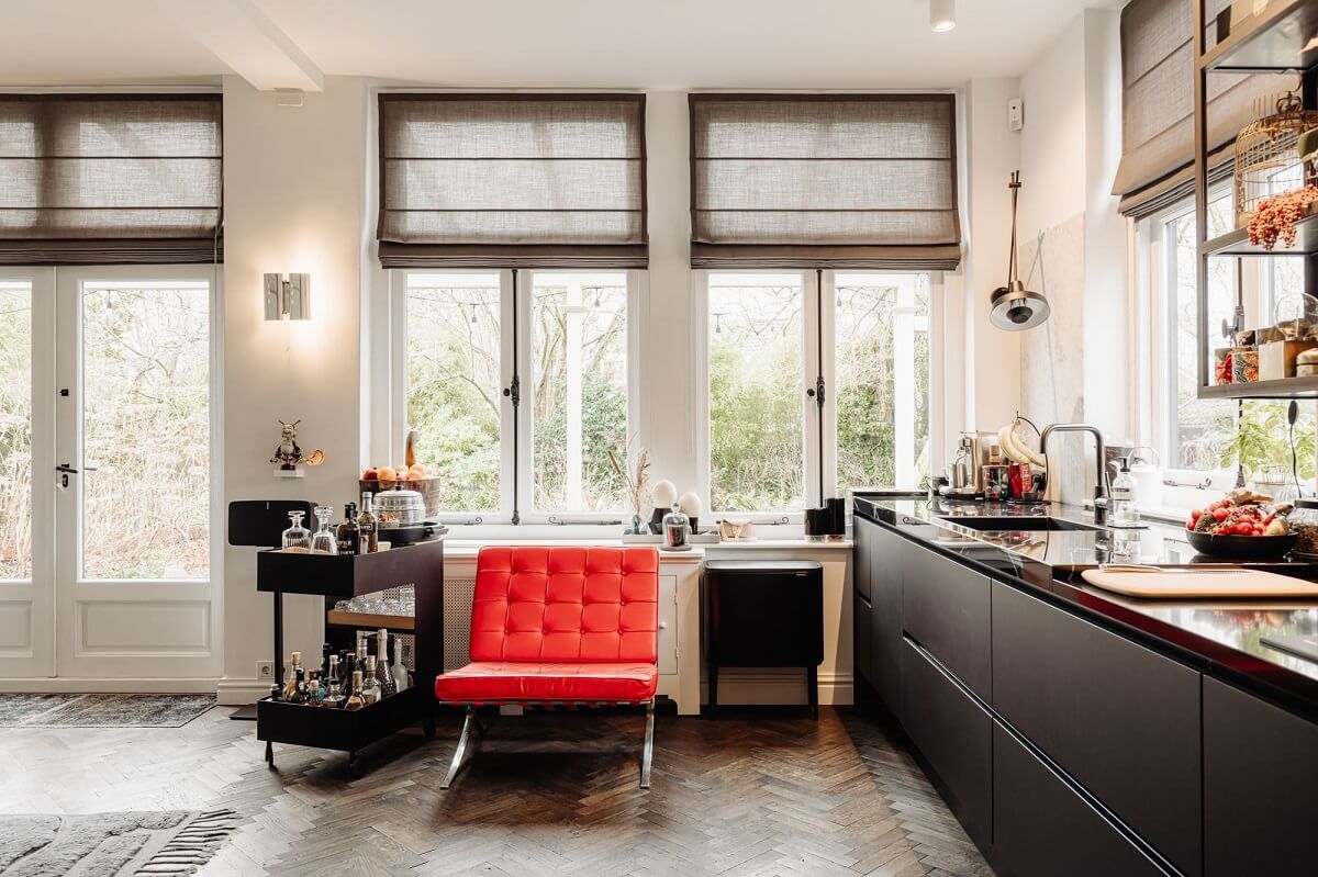 A Beautifully Renovated Dike House in The Netherlands 15 black kitchen with red accent chair