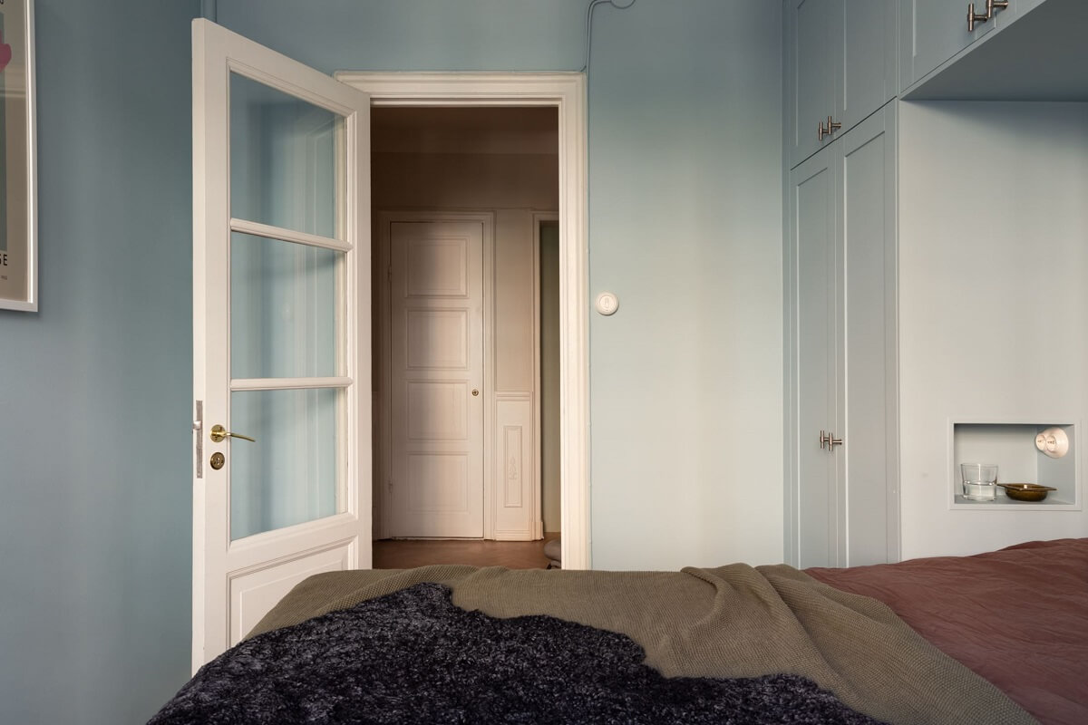A Renovated Swedish Apartment with a Pink Bathroom 14 blue bedroom with custom wardrobes