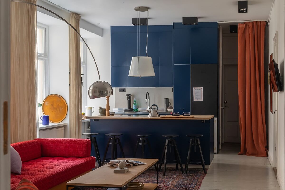Moody Rooms in a Grand Stockholm Apartment 14 blue itchen cabinets and red sofa