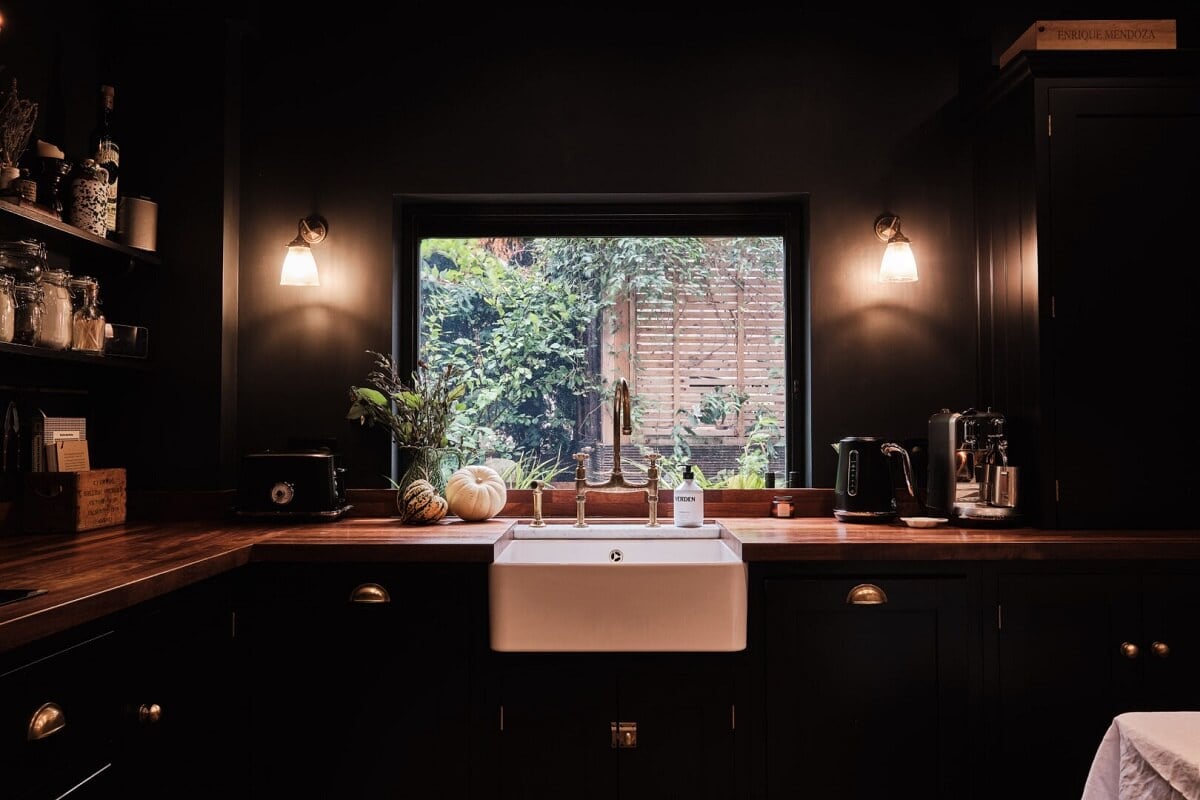 A London Warehouse Conversion with a Black deVOL Kitchen 13 butler sink under window in black devol kitchen