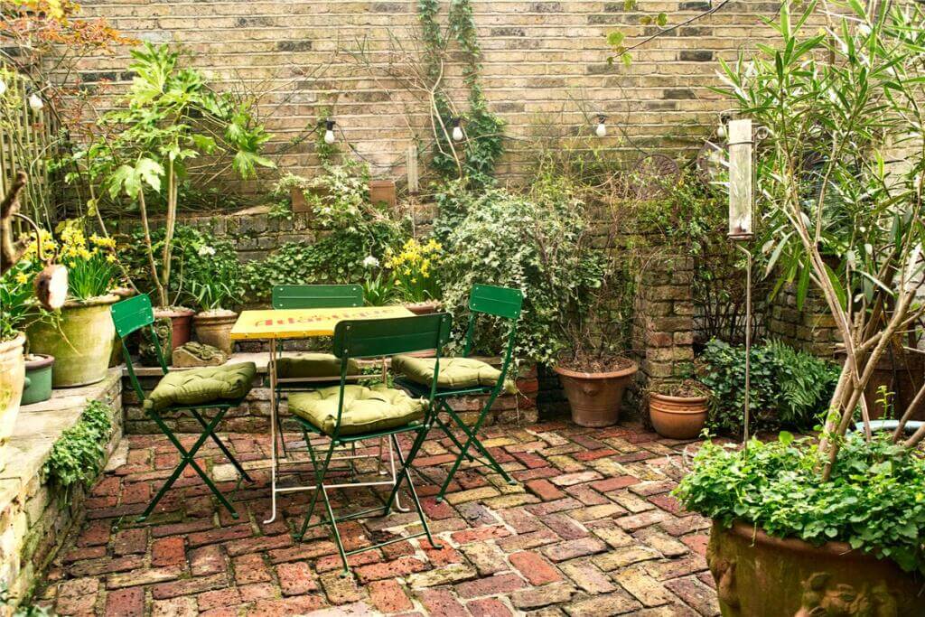 A Warm Muted Color Palette in a Victorian House 39 courtyard garden with bistro seating and plants