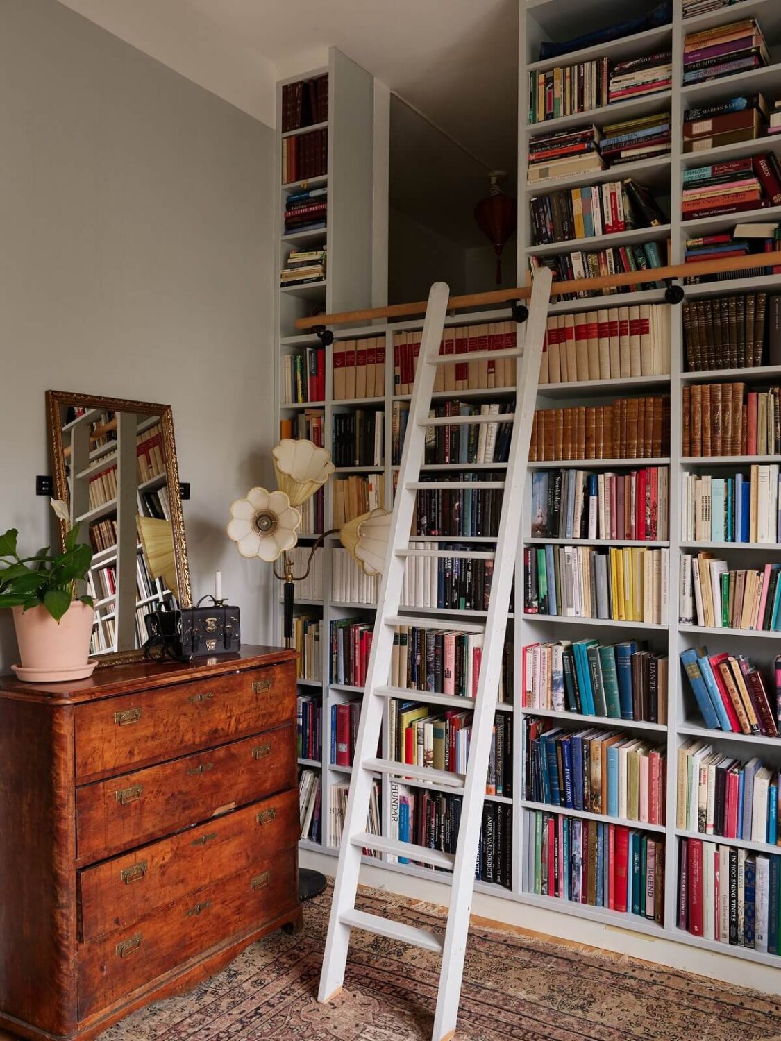 Floor-to-Ceiling Bookcases in a 1950s Swedish Home 2 floor to ceiling bookcases with ladder and loft space
