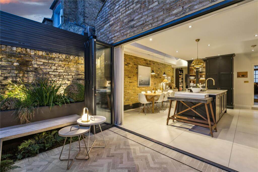 An Extended Victorian House Decorated in Gray Tones 8 garden and extended kitchen space at night