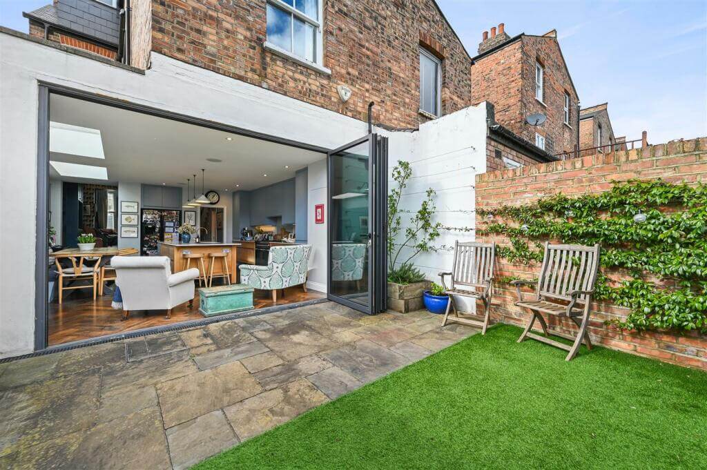 A London Family Home with Blue Color Accents 18 garden with bifolding doors to kitchen