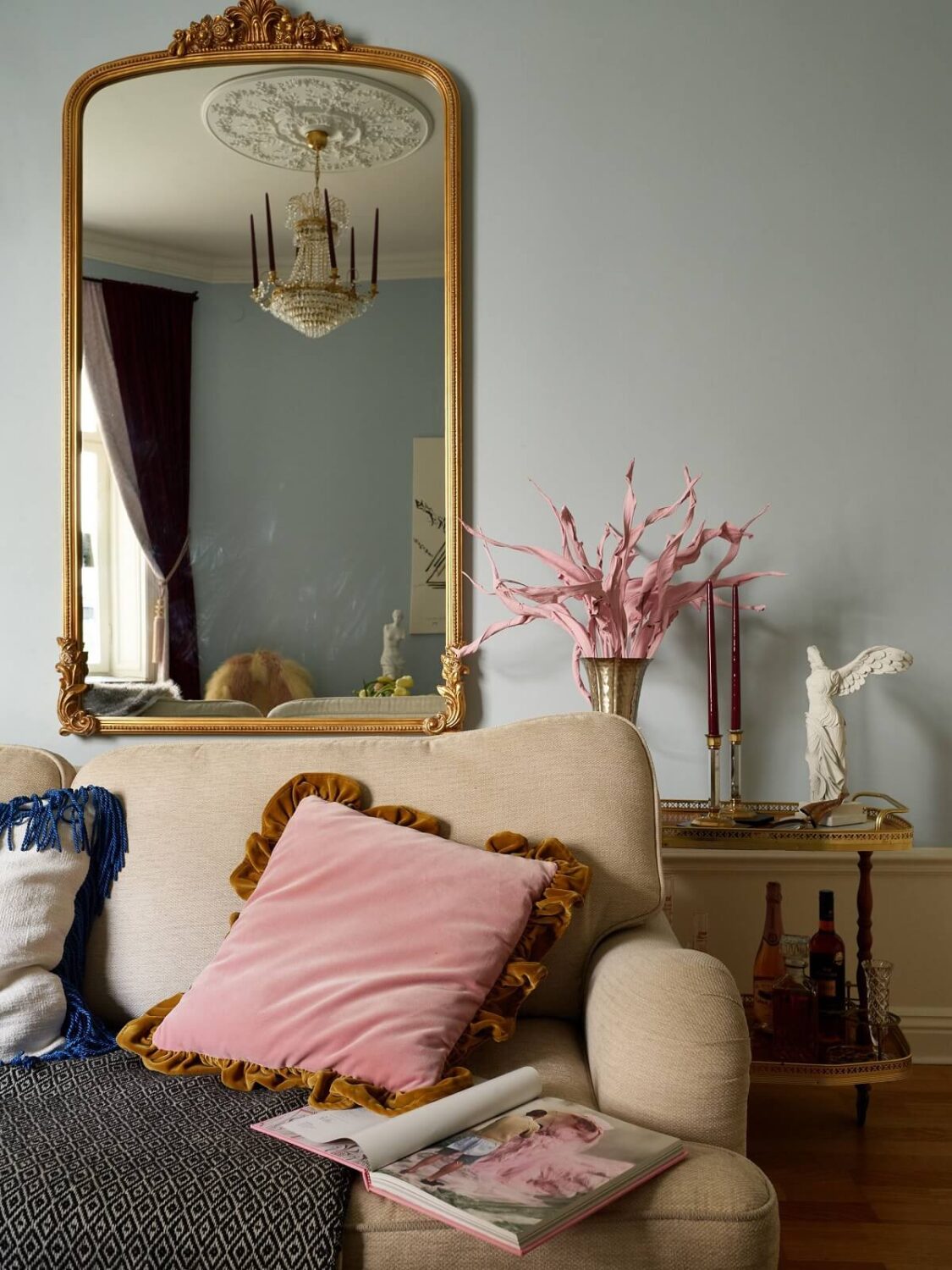 A Classic & Cozy Apartment Painted in Pastel Pink and Blue 3 gilded-mirror-above-sofa-living-room-pastel-blue-walls-nordroom