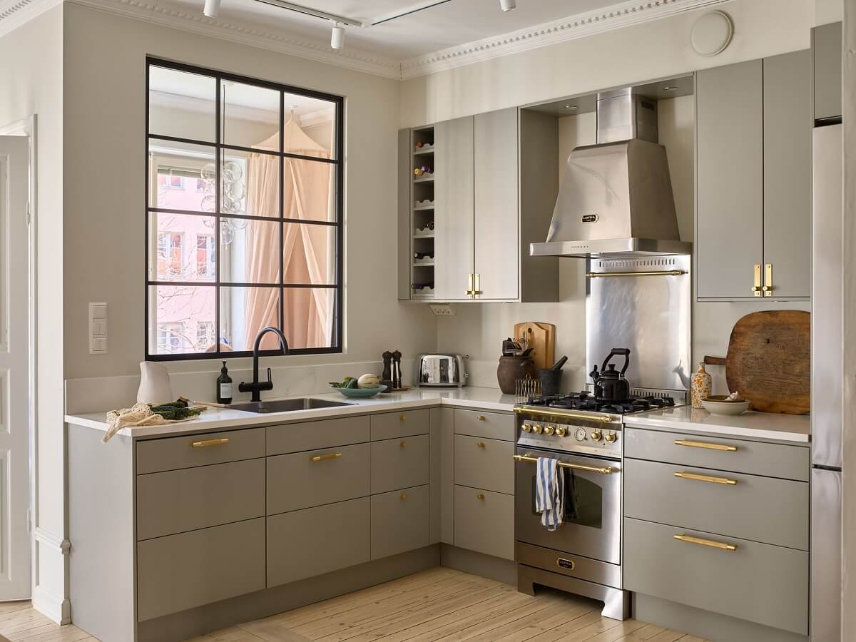 A Social Scandinavian Apartment with a Light Blue Living Room 3 gray kitchen cabinets with brass handles and indoor window