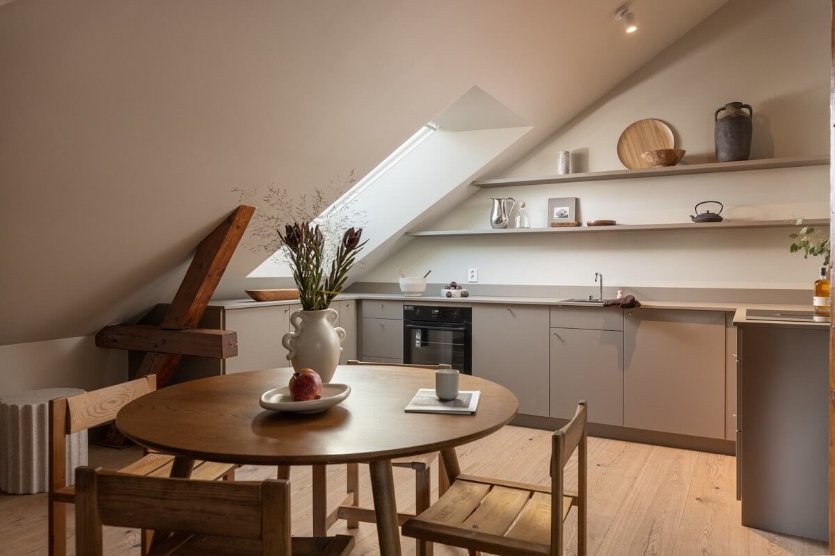 An Attic Apartment in Oslo with Exposed Wooden Beams 7 gray kitchen with round wooden table