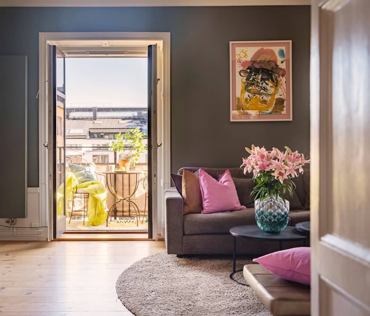 A Classic Swedish Apartment Decorated in Green and Pink Tones 3 green living room with balcony and pink accents