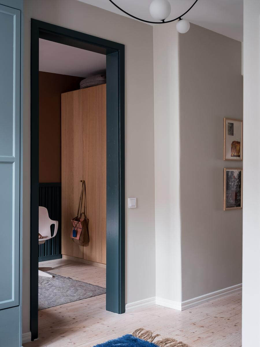 A Beautiful Color Palette in a Scandinavian Family Apartment 25 hallway with blue painted doorframe