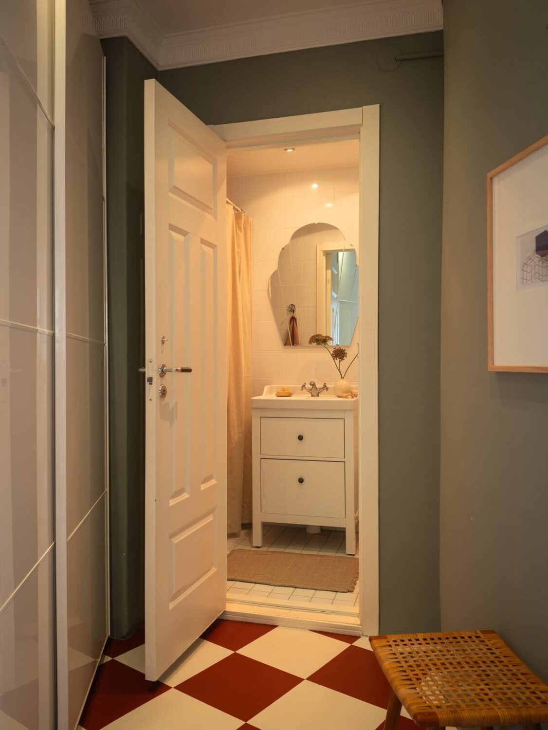 A Scandinavian Apartment with a Warm Living Room and Rounded Walls 21 hallway with checkerboard floor and view of bathroom