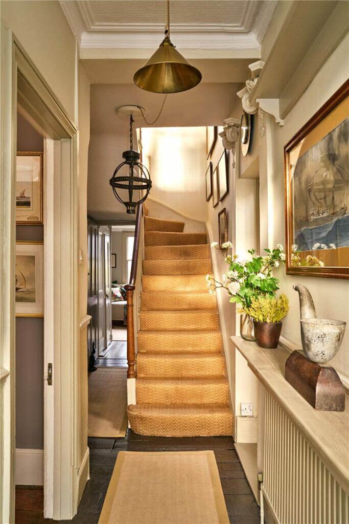 A Warm Muted Color Palette in a Victorian House 26 hallway with shelf above radiator and wooen staircase
