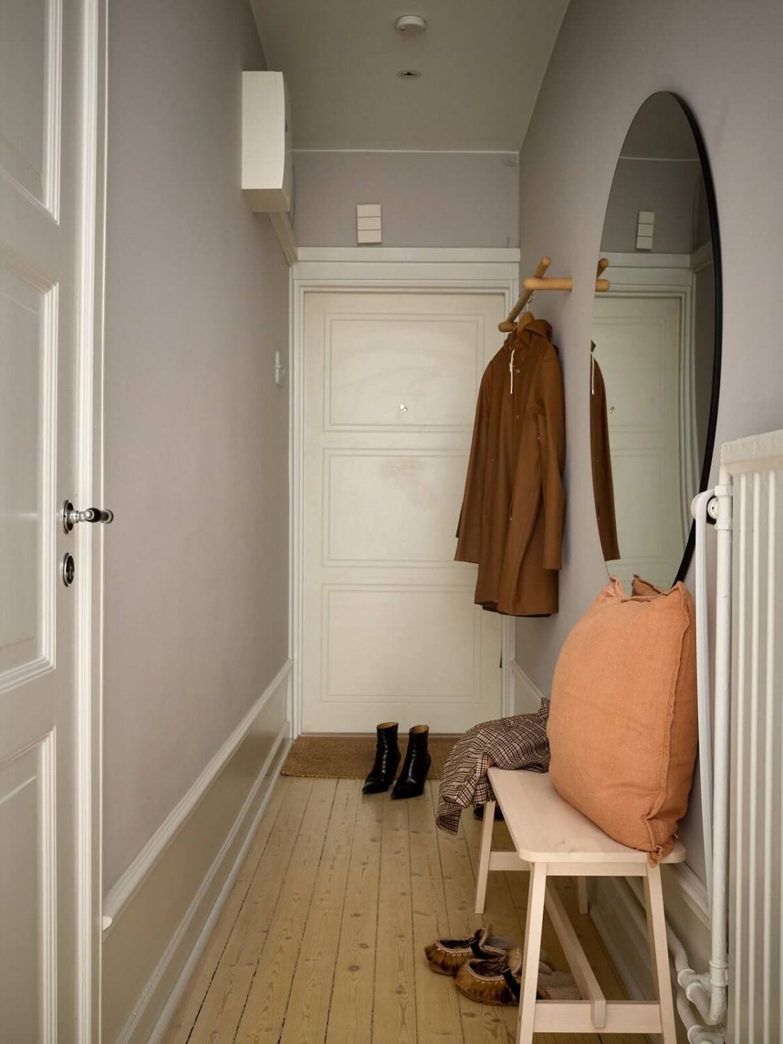 A Social Scandinavian Apartment with a Light Blue Living Room 19 hallway with wooden floor and large round mirror