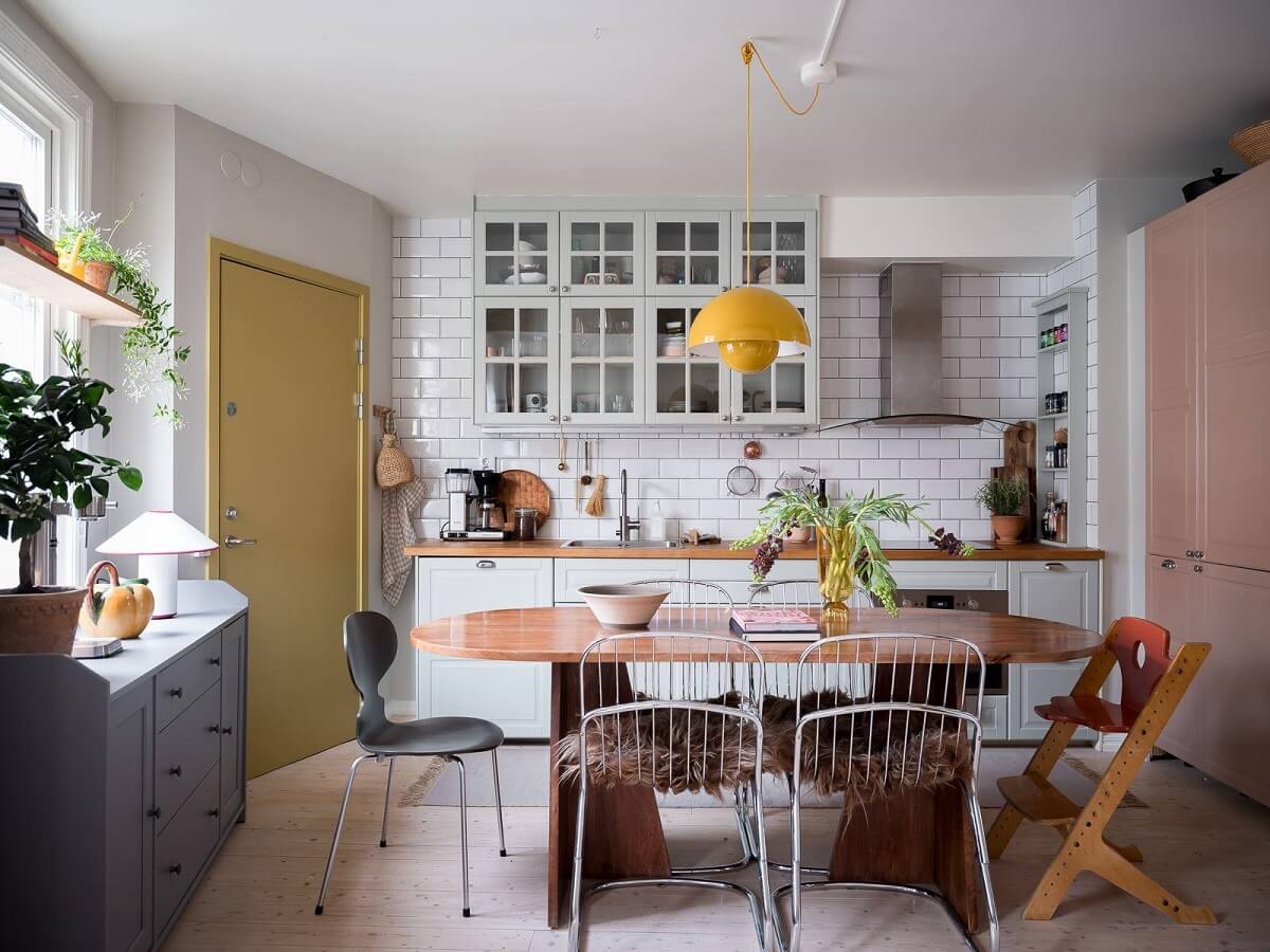 A Beautiful Color Palette in a Scandinavian Family Apartment 3 kitche with yellow pendant and light pink fridge cabinet nordroom