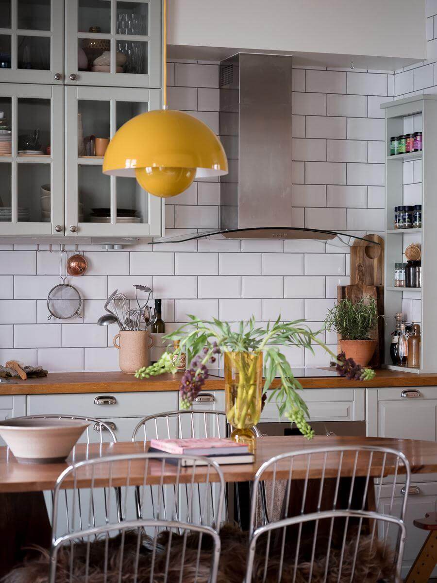 A Beautiful Color Palette in a Scandinavian Family Apartment 4 kitchen dining table with yellow flowerpot pendant