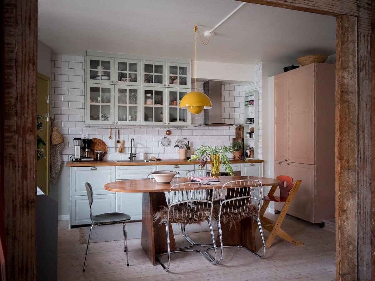 A Beautiful Color Palette in a Scandinavian Family Apartment 5 kitchen with dining table and pink cabinets