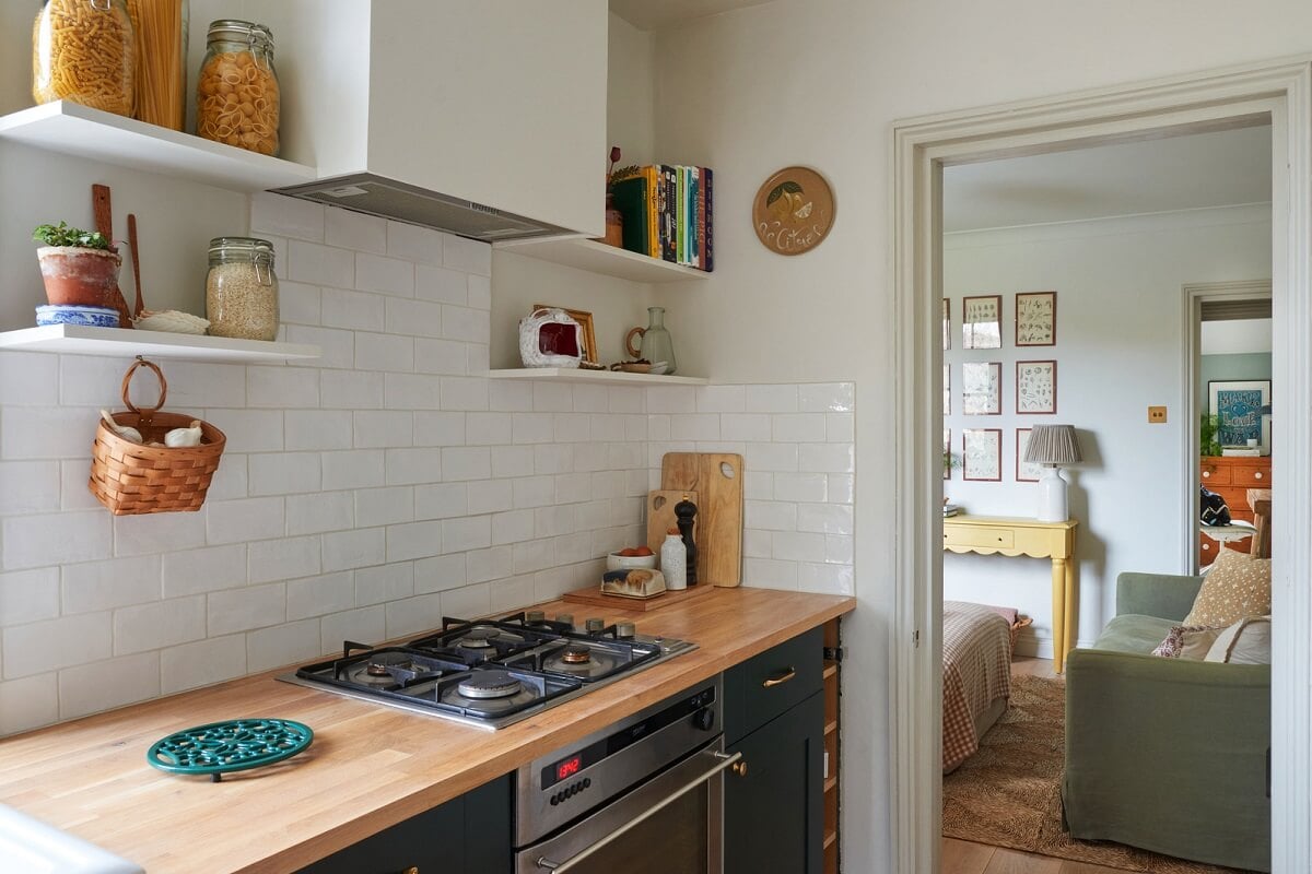 A Small Cottage-Style Apartment in London 9 kitchen with green cabinets and brass fittings