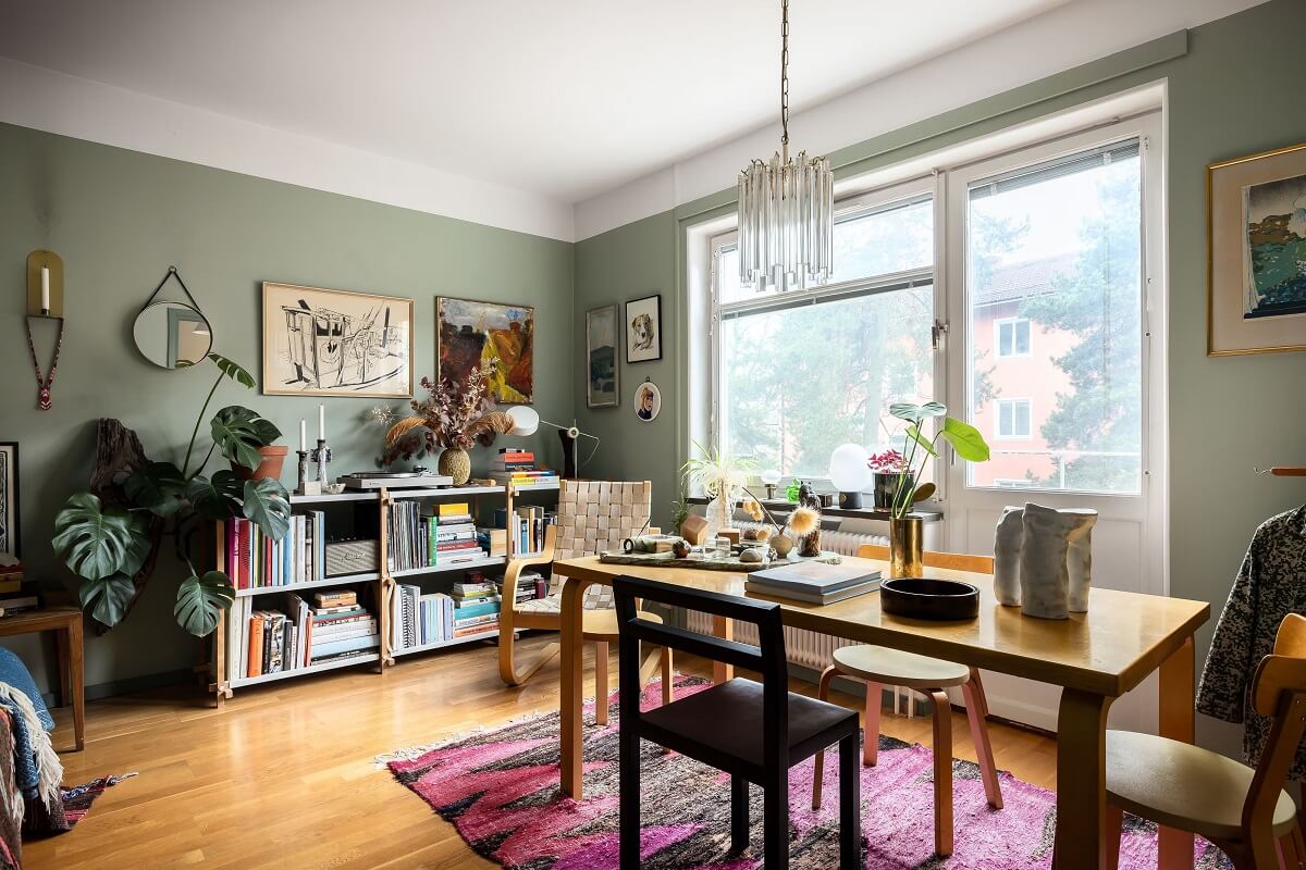 A Cozy Studio Apartment with a Yellow Kitchen 2 large wooden table and plants studio