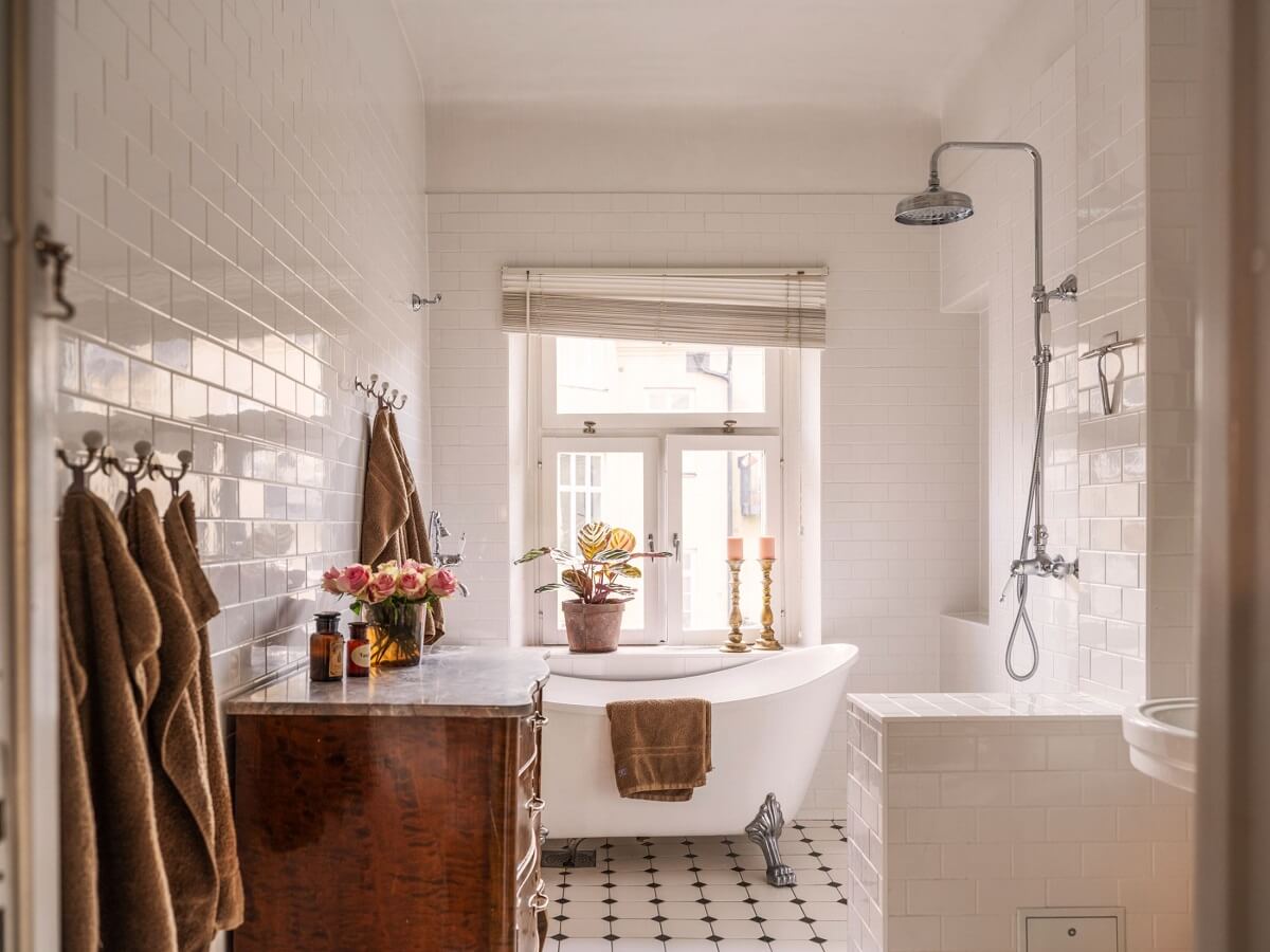 A Classic Swedish Apartment Decorated in Green and Pink Tones 24 light bathroom with clawfoot bath