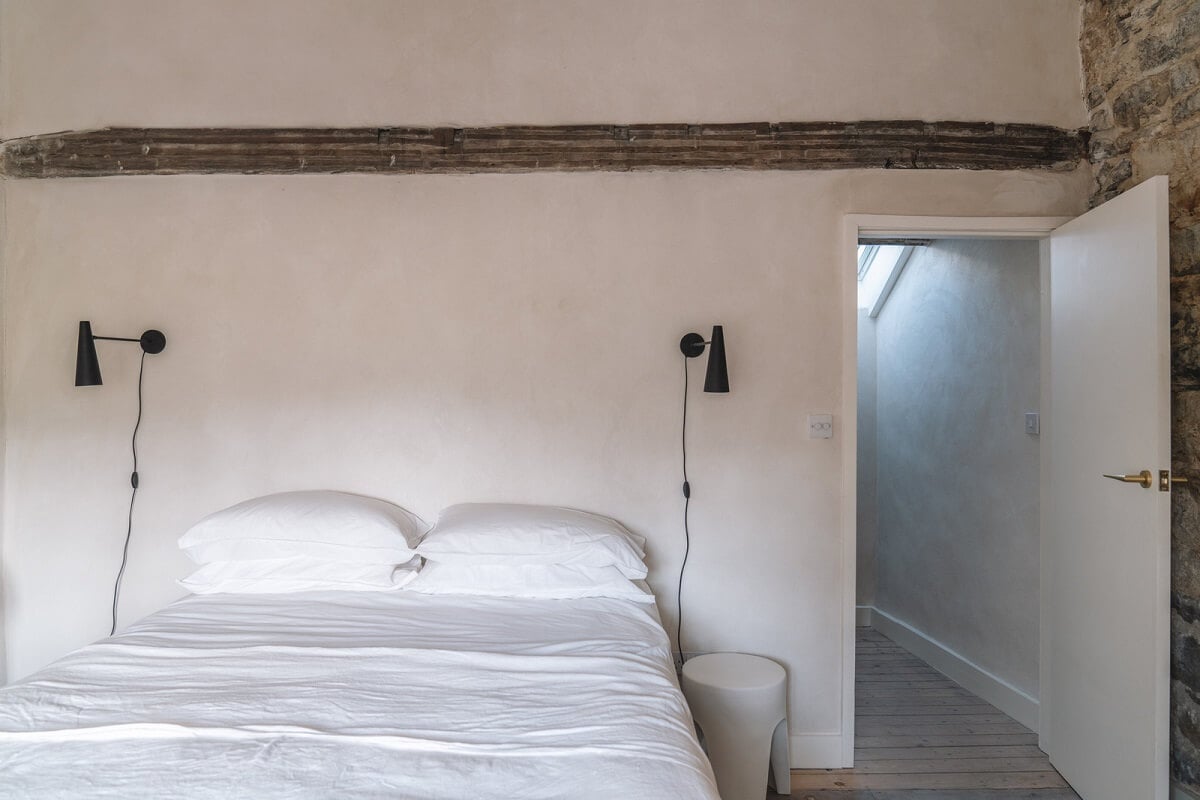 Contemporary Interiors in a Historic English House 13 light colored bedroom with stone wall