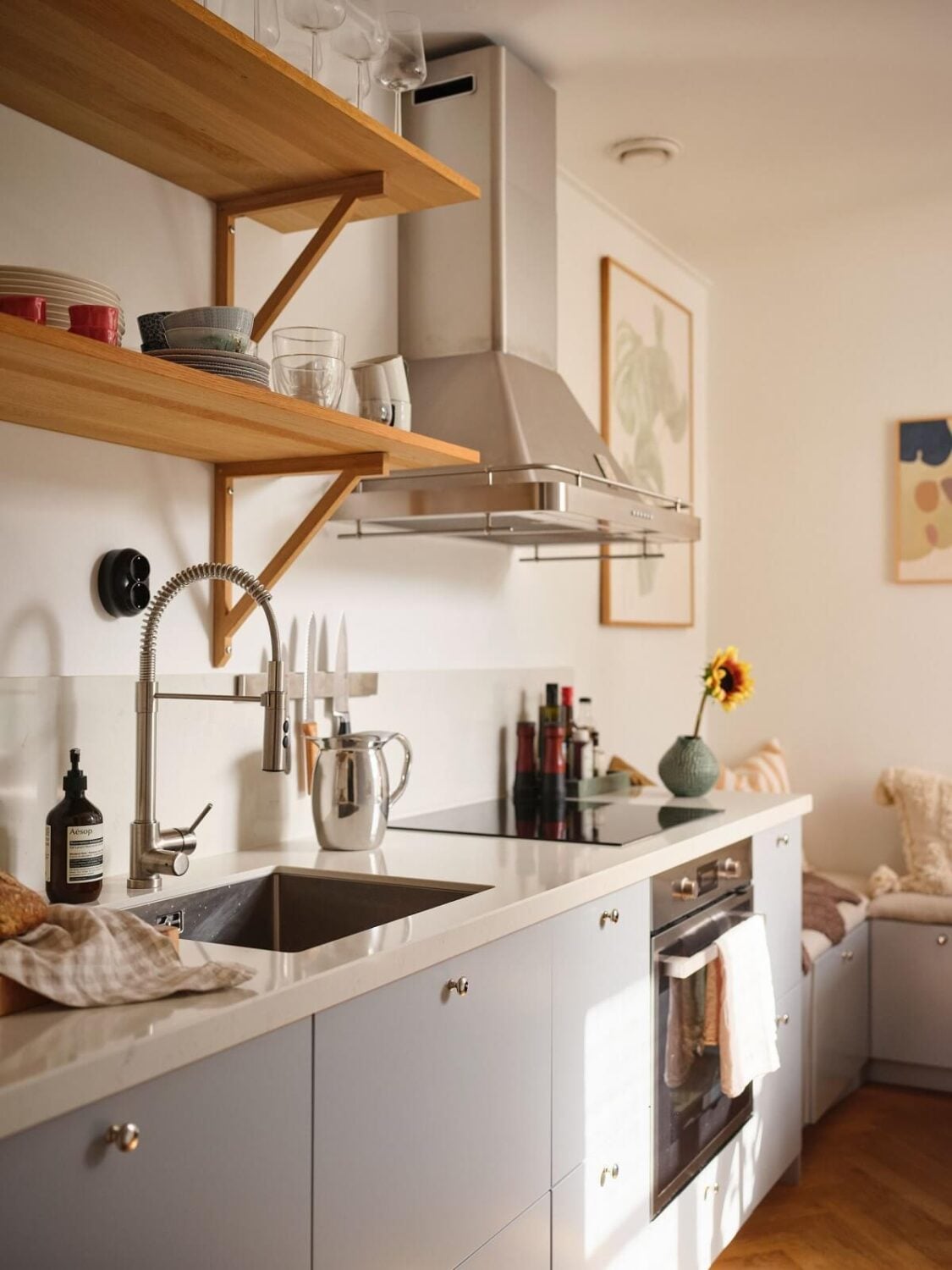 A Light Corner Apartment with a Pink Bedroom 11 light gray cabinets and wooden shelves