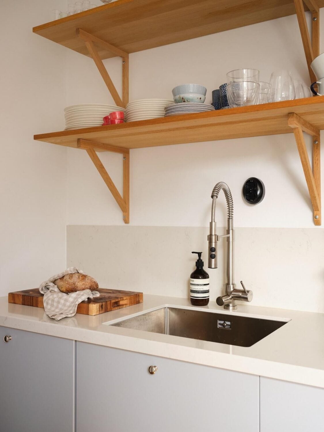 A Light Corner Apartment with a Pink Bedroom 12 light gray kitchen with wooden shelves