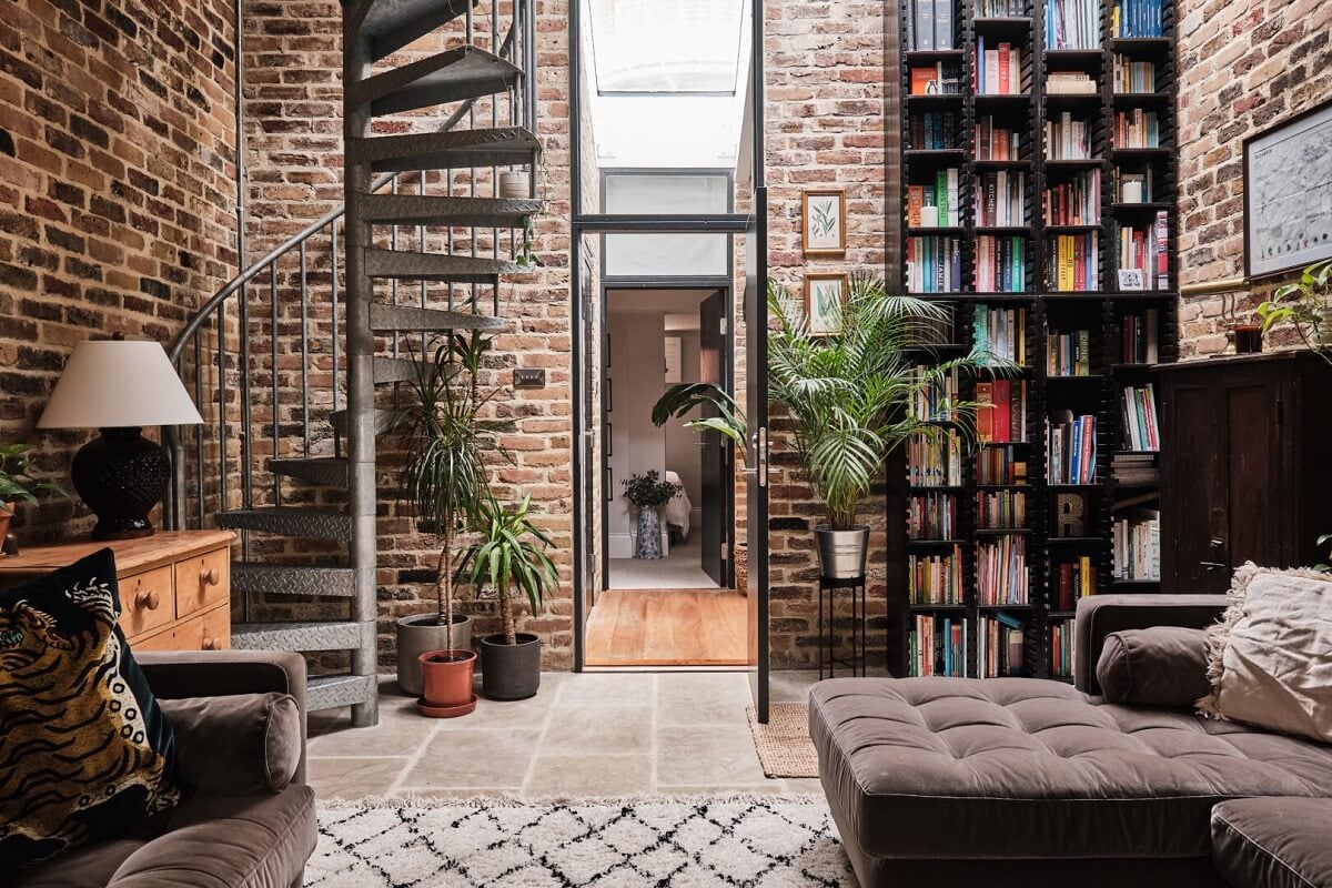 A London Warehouse Conversion with a Black deVOL Kitchen 1 living room with brick walls and floor to ceiling bookcases